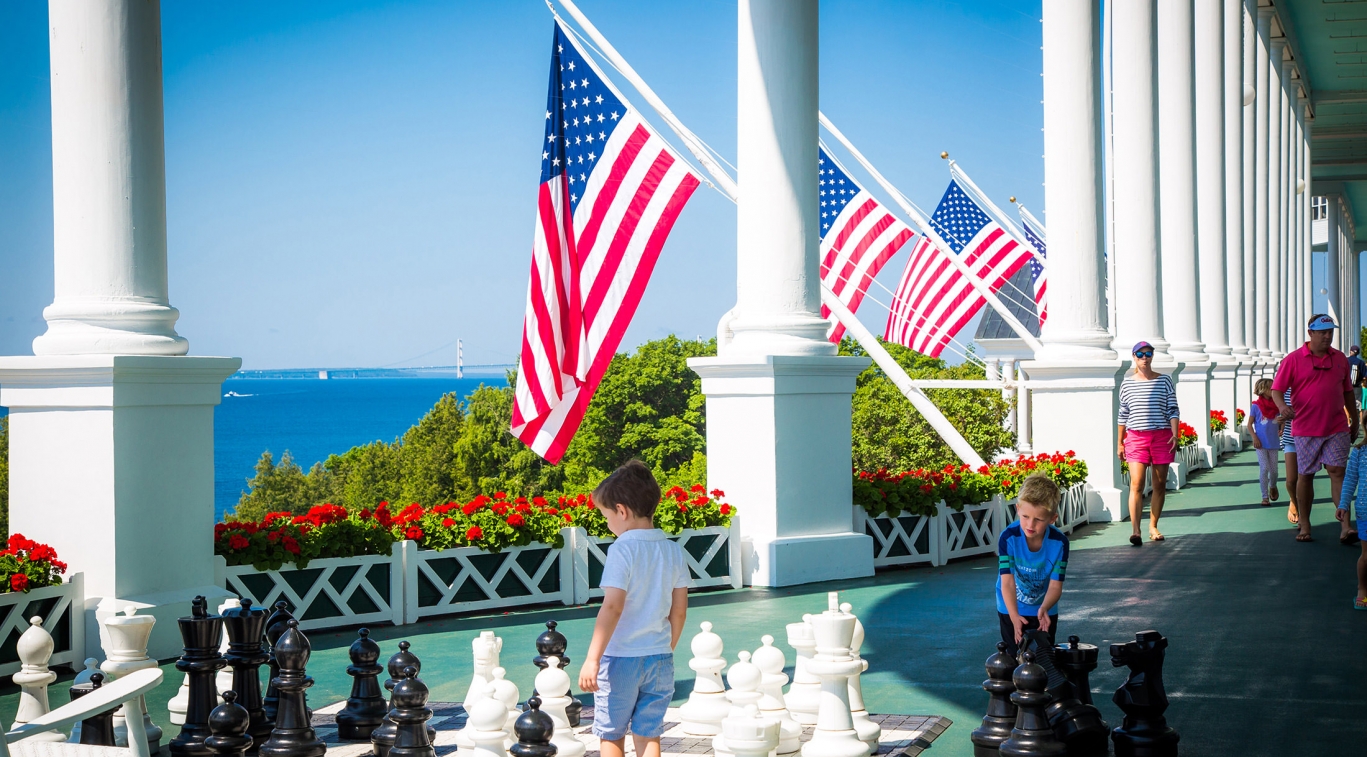 Children playing with large chess board on front porch